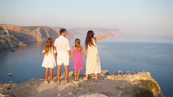 família feliz de quatro pessoas andando nas montanhas no pôr do sol video