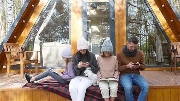 glückliche familie, die im herbst auf der terrasse ihres hauses sitzt video