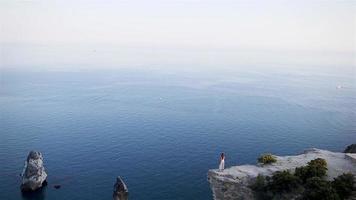 Tourist woman outdoor on edge of cliff seashore video