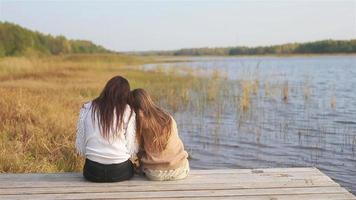 hermosa familia en el cálido día de otoño cerca del lago video