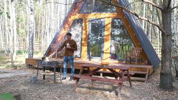 Young man sitting on the wooden old table in the autumn forest video