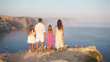 contento famiglia di quattro a piedi nel il montagne su il tramonto video