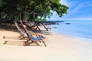 Bamboo deck chairs on the sandy beach with bright sun and waves, Island south of THAILAND. Relaxing day at the beach photo