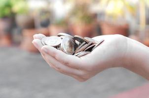 monedas en manos ahorro, donación inversión fondo financiero apoyo caridad dividendo mercado casa valores confiar rico dando planificado contabilidad colección deuda bancario roi foto