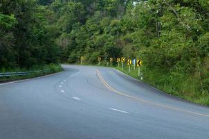 Countryside road with trees on both sides,Curve of the road to mountain photo