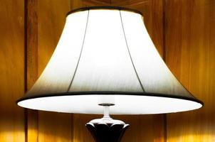 Elegant lamp in warm interior room,Turned On Old Lamp near the wooden wall photo