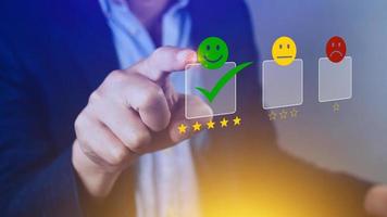 Businessman choosing happy smile face icon. feedback rating and positive customer review experience, satisfaction survey. mental health assessment. photo