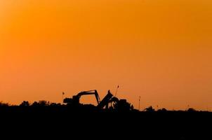 silhouette of excavator loader at construction site,Silhouette Backhoe,track-type loader excavator machine doing earthmoving photo