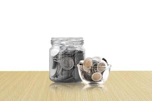 coins in a glass jar on Wood floor ,savings coins - Investment And Interest Concept saving money concept, growing money on piggy bank. isolated on white background photo