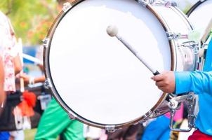 Drummer in blue uniforms a Marching Band. Drummer plays big drum in parade photo