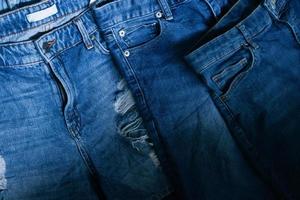 Stack of various shades blue jeans. Pile Blue denim jeans texture banner. Canvas denim fashion texture photo
