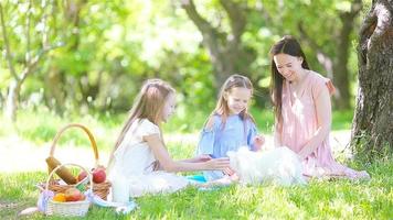 la madre feliz y las hijas pequeñas se relajan junto al lago video