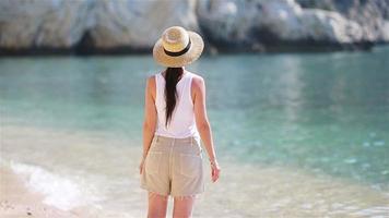 mujer hermosa joven en la playa tropical de arena blanca. chica caucásica con sombrero de fondo el mar video