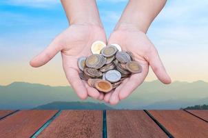 Coins in hands on Landscape background,Donation Investment Fund Financial Support Charity  Dividend Market Growth Home photo