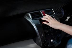 woman finger pressing car emergency light button in car photo