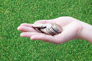 Coins in hands on grass,Donation Investment Fund Financial Support Charity  Dividend Market Growth Home House Stock Trust Wealthy Giving Planned Accounting Collection Debt Banking ROI concept photo