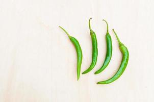 Fresco verde caliente chile pimientos con picante en el de madera foto