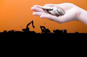 Coins in hands on Industry  silhouette Landscape background,Donation Investment Fund Financial Support Charity  Dividend Market Growth Home House Stock Trust Wealthy Giving Planned Accounting photo