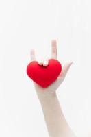 Love sign by woman hand and red heart shape on white background close-up,Symbol of love or dating Valentines day photo