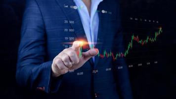 Businessman finger touch symbol stock graph and chart background, concept growth and development business investment, Stock market and strategy making market plan and stock market fluctuations photo