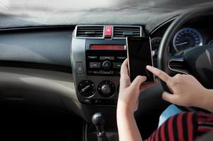 Hand hold smartphone in car,People press point the phone while driving photo