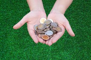 Coins in hands on grass,Donation Investment Fund Financial Support Charity  Dividend Market Growth Home House Stock Trust Wealthy Giving Planned Accounting Collection Debt Banking ROI concept photo