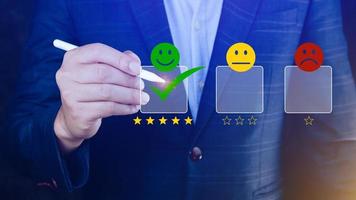 Businessman choosing happy smile face icon. feedback rating and positive customer review experience, satisfaction survey. mental health assessment. photo