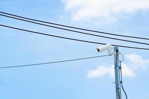 Modern CCTV camera installed outdoor on blue sky photo