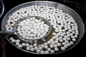 Cooking meat balls in hot pot.Boiled meat ball in hot water in asia tradition street market at Thailand photo