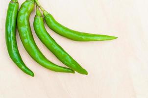 fresh green hot chilli peppers with spicy on the wooden photo