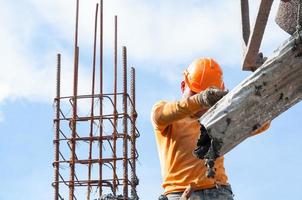 Construction building workers at construction site pouring concrete in form,Man Working at height with blue sky at construction site photo