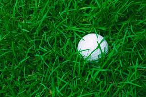 Green grass with golf ball close-up in soft focus at sunlight. Sport playground for golf club concept photo