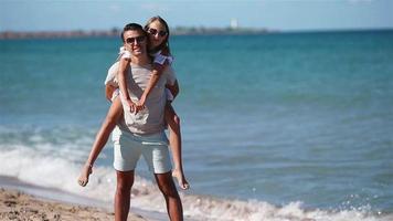 poco ragazza e contento papà avendo divertimento durante spiaggia vacanza video