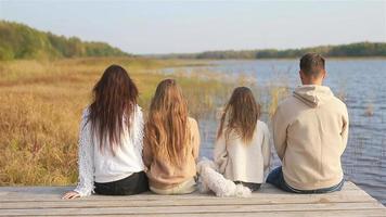 hermosa familia en el cálido día de otoño cerca del lago video