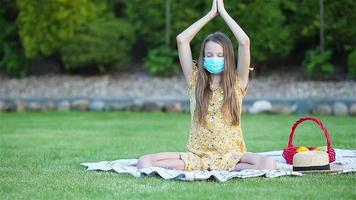 weinig meisje in yoga positie in de park. video