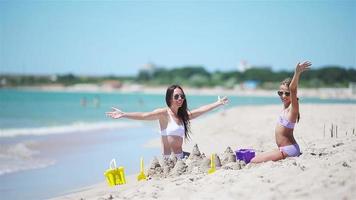 Beautiful mother and daughter on the beach enjoying summer vacation video