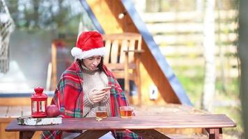 jeune famille en bonnet de noel assis sur le vieux fond de table en bois de leur maison video