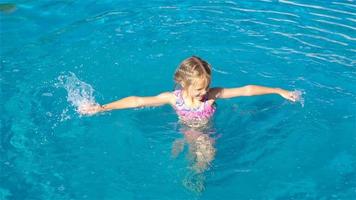 Adorable little girl in outdoor swimming pool video