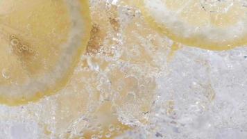 Soda water with ice cubes and sliced lemon slow motion video. video