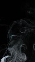 Slow motion vertical video of white smoke, fog, mist, vapor on a black background.