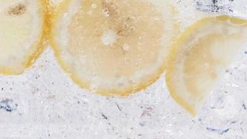 Soda water with ice cubes and sliced lemon slow motion video. video