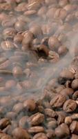 Vertical slow motion of roasted coffee beans falling. Organic coffee seeds. video