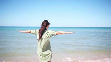 giovane bellissimo donna avendo divertimento su tropicale spiaggia. contento ragazza sfondo il blu cielo e turchese acqua nel il mare video