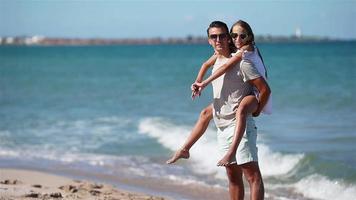 weinig meisje en gelukkig vader hebben pret gedurende strand vakantie video