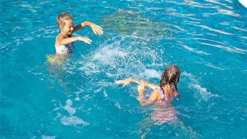 Adorable little girls in outdoor swimming pool video