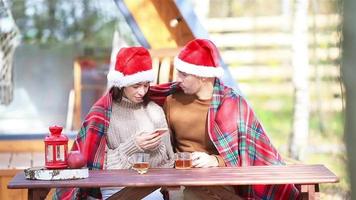 Young family in santa hat sitting on the wooden old table background of their house video