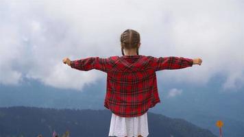 hermosa niña feliz en las montañas en el fondo de la niebla video