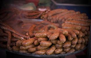 An outdoor food stall selling grilled homemade sausages photo