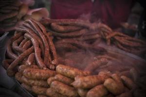 An outdoor food stall selling grilled homemade sausages photo