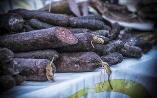 An outdoor stall with a bunch of homemade sausages for sale photo